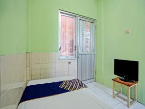 Habitación pequeña con cama y TV. en OYO Life 92653 Homestay Griya Nautika Syariah en Surabaya