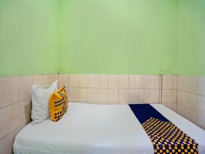 a bed in a room with two pillows on it at OYO Life 92653 Homestay Griya Nautika Syariah in Surabaya
