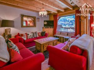 a living room with red furniture and a large window at Chalet Le Grand-Bornand, 8 pièces, 16 personnes - FR-1-391-33 in Le Grand-Bornand