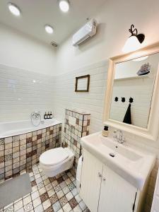 a bathroom with a toilet and a sink and a mirror at The Spot with Green Chair - cozy space near Danube in Budapest