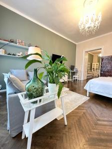 a living room with a couch and a table with a vase at The Spot with Green Chair - cozy space near Danube in Budapest