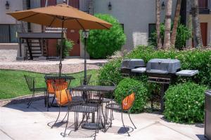 un patio con mesas, sillas y una sombrilla en 220 Fully Furnished, WiFi Included, en Scottsdale