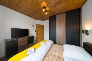 1 dormitorio con 1 cama y TV de pantalla plana en Apartmán B4 Hrabušice, en Hrabušice