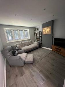 a living room with a couch and a television at Superb Three Bed Garnant Duplex! in Garnant
