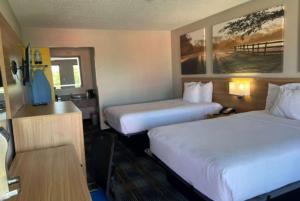 A bed or beds in a room at Days Inn & Suites Mobile