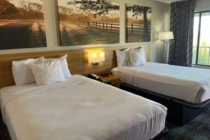 Кровать или кровати в номере Days Inn & Suites Mobile