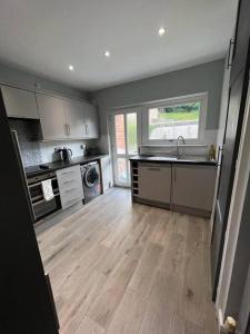 a kitchen with wooden floors and a kitchen with a sink at Superb Three Bed Garnant Duplex! in Garnant