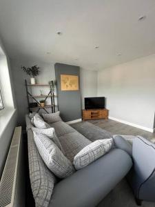een woonkamer met een bank en een televisie bij Superb Three Bed Garnant Duplex! in Garnant