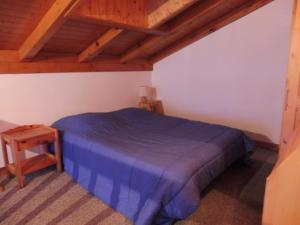 um quarto com uma cama azul e um tecto de madeira em Appartement Crest-Voland, 2 pièces, 6 personnes - FR-1-595-80 em Crest-Voland