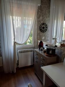 eine Küche mit einem Tisch und ein Fenster mit Vorhängen in der Unterkunft 4 PASSI DAL CENTRO in Brescia