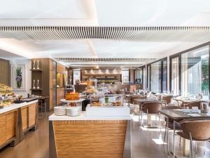 een restaurant met tafels en stoelen en een cafetaria bij Mercure Villa Romanazzi Carducci Bari in Bari