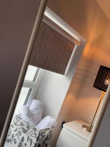 a room with a window with a chair and a lamp at No 16 Main Accommodation in Buncrana