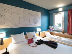 a bedroom with a bed with a pair of glasses on it at Hotel ibis Narbonne in Narbonne