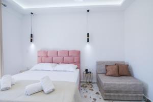 a bedroom with a pink headboard and a chair at Anais Luxury Living Grey & Pink by CorfuEscapes in Marathias