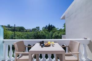 a white table and chairs on a balcony at Anais Luxury Living Grey & Pink by CorfuEscapes in Marathias