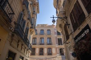 ein großes Gebäude inmitten zweier Gebäude in der Unterkunft Apartamento-Loft Especería Black in Málaga