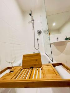 a shower with a wooden seat in a bath tub at Beautiful Central Open plan living! in Manchester