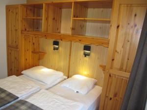 um quarto com 2 camas com paredes e prateleiras de madeira em Wohnung CHOTTES NEND230 em Nendaz