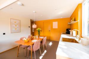 a dining room with orange walls and a table and chairs at Residenties en bungalow Royal Domburg in Domburg