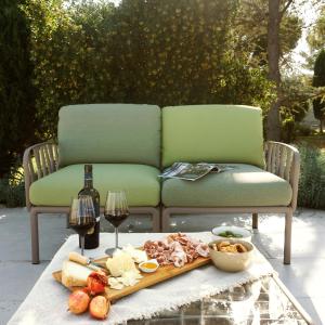 Otto Apulia House B&B في أندريا: طاولة مع أريكة مع صينية من الطعام والنبيذ