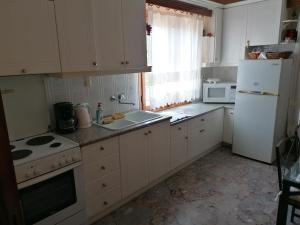 a kitchen with a white refrigerator and a sink at Genesis in Kastraki