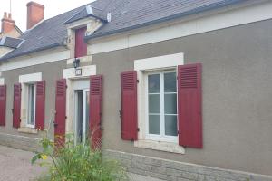 a row of red shuttered windows on a building at Bienvenue chez nous 