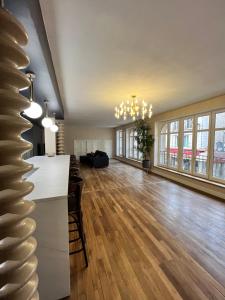 a large living room with wood floors and a chandelier at Loft me - Entre art deco et loft à l'americaine in Périgueux