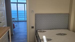 um quarto com uma cama e vista para o oceano em Yen's Home em Karaburun