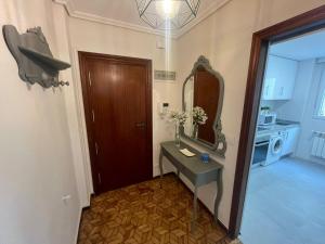 uma casa de banho com uma mesa, um espelho e uma porta em Piso cerca de las estaciones em Santander