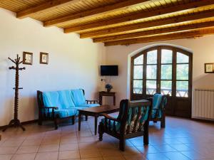 een woonkamer met een tafel en blauwe stoelen bij Agriturismo Poderino in Castiglione di Garfagnana