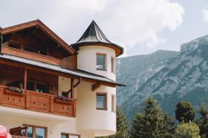 a building with a balcony with mountains in the background at loisi's Boutiquehotel in Achenkirch