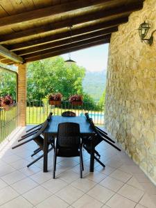 uma mesa e cadeiras num pátio com uma parede de pedra em Agriturismo Poderino em Castiglione di Garfagnana