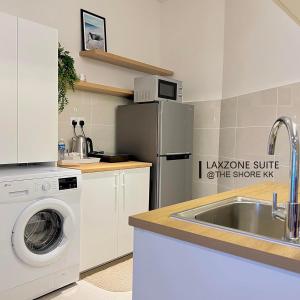 a kitchen with a washing machine and a sink at The Shore CBD Kota Kinabalu By LAXZONE SUITE in Kota Kinabalu