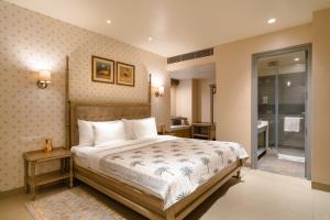 a bedroom with a large bed and a bathroom at Rupal Residency in Jaisalmer