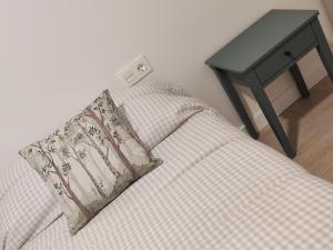 a couch with a pillow next to a side table at Txoko Loft Bardenas in Tudela