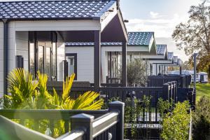 a house with a fence in front of it at Amici Camping Urlaub am Effelder Waldsee in Wassenberg