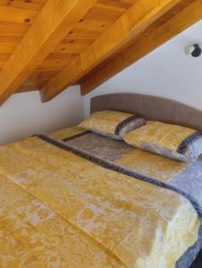 een bed met twee kussens op zolder bij WOODSTONE APARTMAN in Podgorica