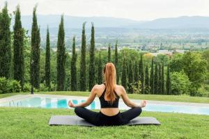a woman doing yoga in front of a pool at La Conca in Sansepolcro