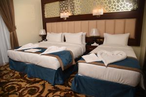 two beds in a hotel room with towels on them at فندق الاندلس الماسى in Al Madinah