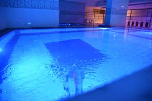 a dog is swimming in a swimming pool at فندق الاندلس الماسى in Al Madinah
