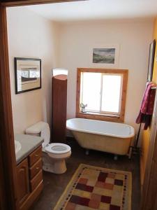 a bathroom with a tub and a toilet and a sink at Towerhouse - Modern Cabin @ 8,000ft in Wanship