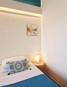 a bedroom with a bed with a pillow and a lamp at Boutique Hotel Die Zwei Brüder in Matala