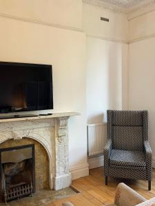 a living room with a fireplace and a television on a wall at Budget room en-suite 8mins walk to Singleton Hospital, R3 in Sketty