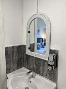 La salle de bains est pourvue d'un lavabo et d'un miroir. dans l'établissement Budget room en-suite 8mins walk to Singleton Hospital, R3, à Sketty