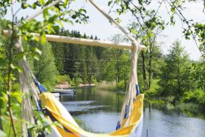 a hammock hanging over a river with a view of a river at Riverside Bliss Idyllic Camp, 3 Man Tent Incl, near Tvedestrand and Arendal in Vegårshei