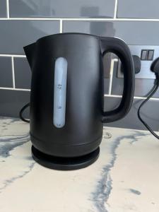 a black mug with a remote control in it on a counter at Lovely apartment for 2 or 4 people - Bermondsey in London