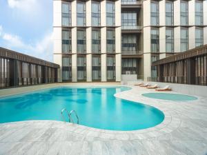 une grande piscine en face d'un bâtiment dans l'établissement Four Points by Sheraton Guangzhou, Baiyun, à Canton