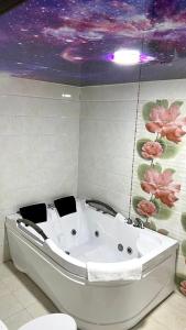a bath tub in a bathroom with a purple ceiling at Za'faron Hotel in Jizzax +65 photos