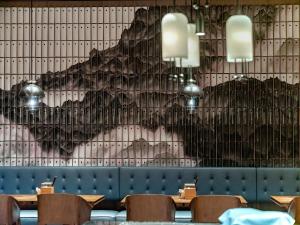 a restaurant with tables and chairs in front of a wall at Four Points by Sheraton Guangzhou, Baiyun in Guangzhou