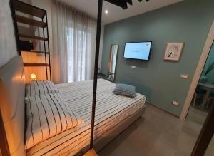 ein Schlafzimmer mit einem Etagenbett und einem Flachbild-TV in der Unterkunft Playa degli Angeli Grecale in Gabicce Mare